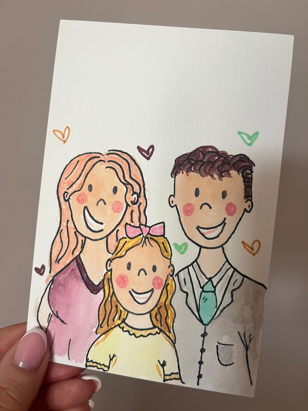Watercolour doodle of a family of three — two parents and a little girl with a pink bow