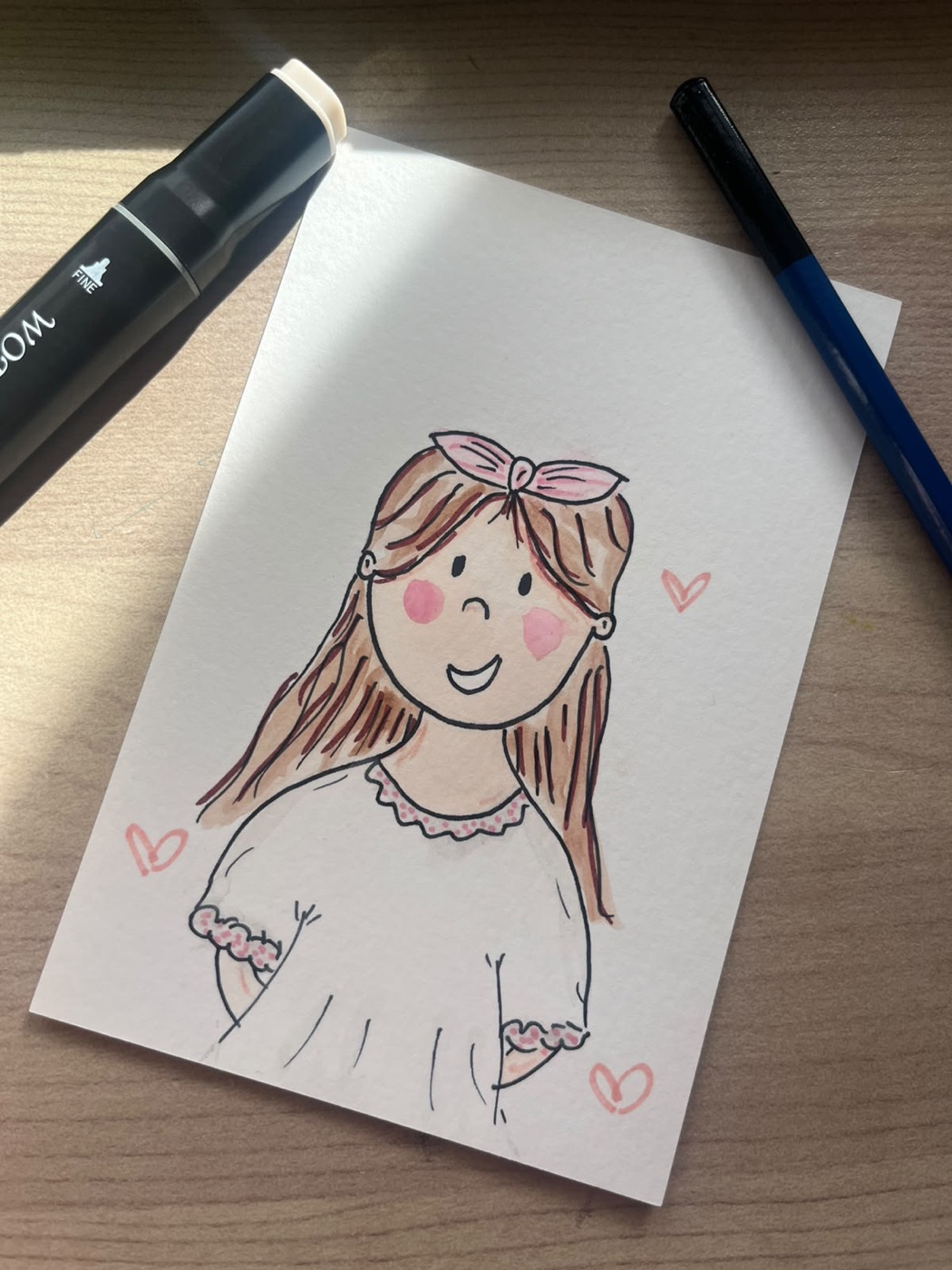 Watercolour doodle of a guest with long hair, a pink bow and rosy cheeks, surrounded by little hearts